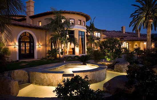 Luxurious house with a lit pool and elegant landscaping at dusk. Luxurious house with a lit pool and elegant landscaping at dusk.